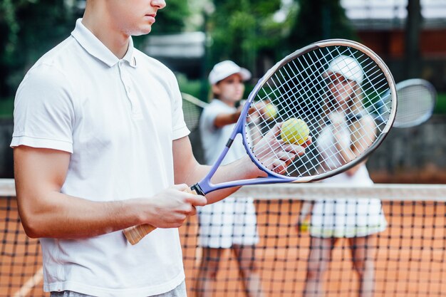 Man die met beide handen een tennisracket zwaait om een sterk schot te maken. Oefen 's avonds voor een wedstrijd.