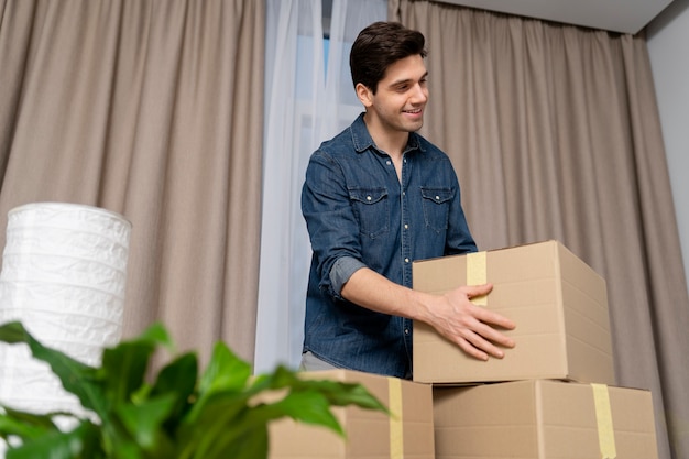 Man die met spullen omgaat na verhuizing naar nieuw huis