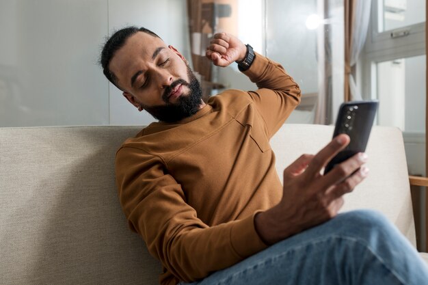 Man die moe is na tijd op zijn smartphone te hebben doorgebracht