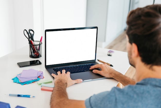 Man die op laptop op Bureau met briefpapier typen