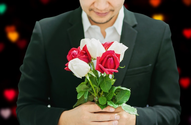 Man die rode en witte boeket rozen geeft aan iemand in Valentijnsdag