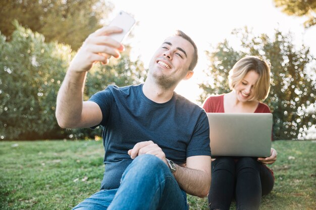 Man die selfie dichtbij vrouw met laptop nemen