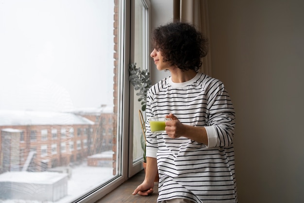 Man die thuis geniet van een kopje matcha-thee