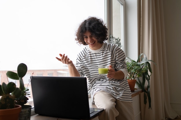 Gratis foto man die thuis geniet van een kopje matcha-thee