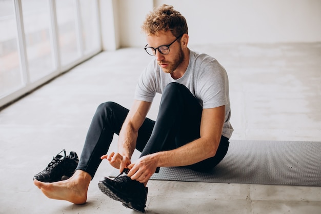 Man die thuis yoga beoefent op de mat