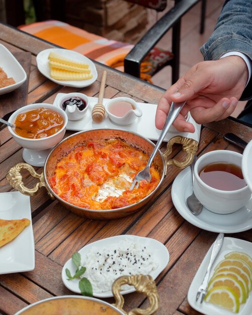 man die tomaat en ei schotel met vork bij traditioneel ontbijt
