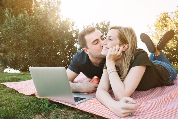 Man die vrolijke vrouw op picknick kussen