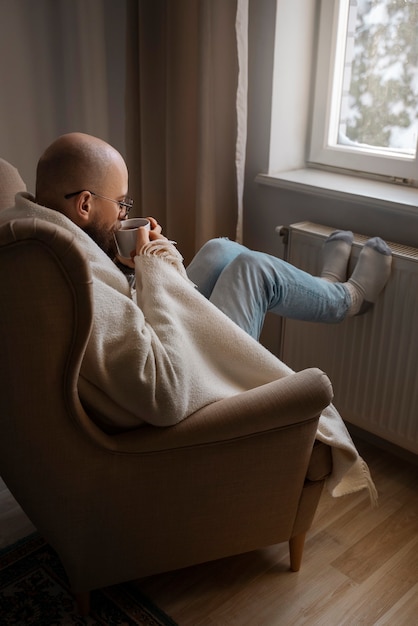 Man die warme drank drinkt tijdens energiecrisis