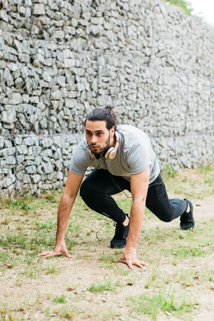 Man die zich uitstrekt buiten voor hardlopen