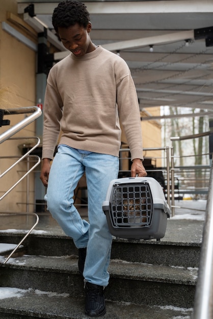 Gratis foto man die zijn huisdier in een koets buiten vervoert