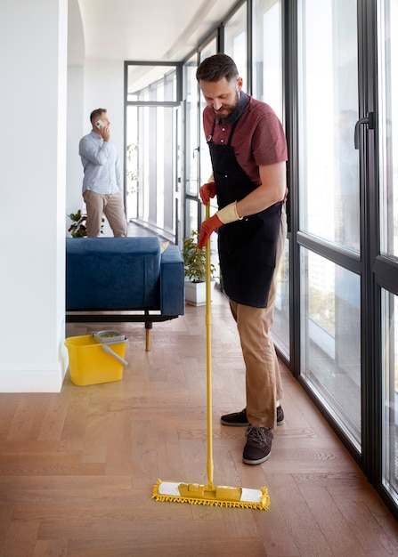 Man dienaar maakt het huis schoon