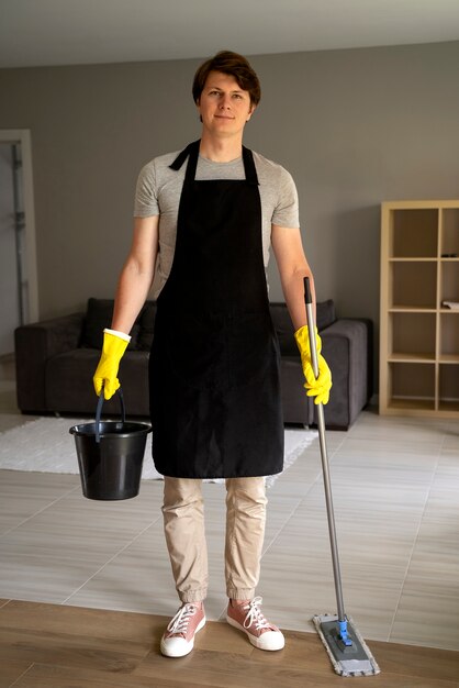 Man dienaar maakt het huis schoon