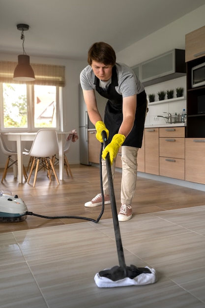 Man dienaar maakt het huis schoon