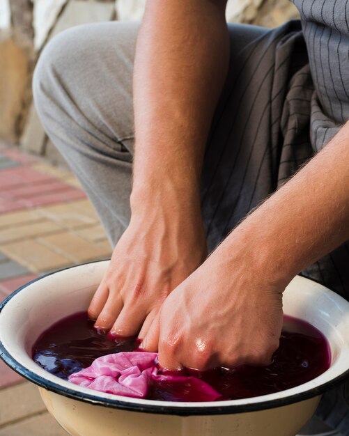 Man doorweekte doek in roze natuurlijk pigment