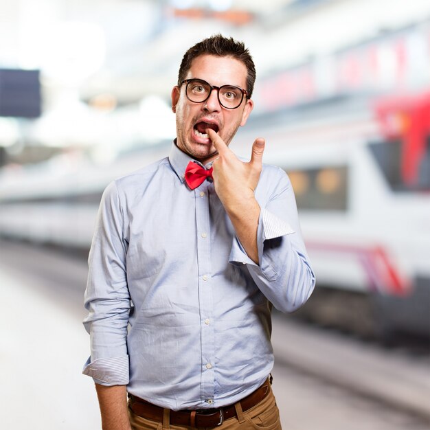 Man draagt ​​een rode vlinderdas. Het doen van een pistool gebaar.