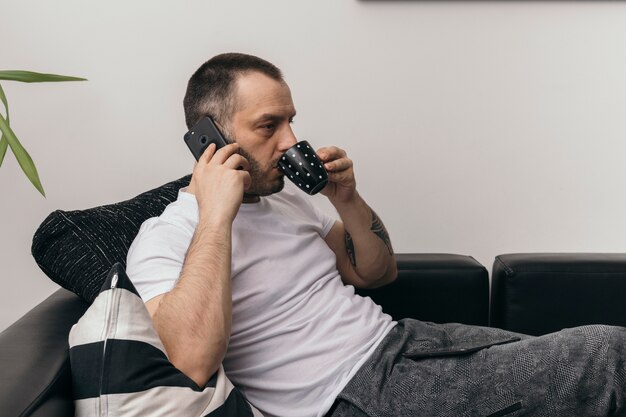 Man drinken en spreken op telefoon