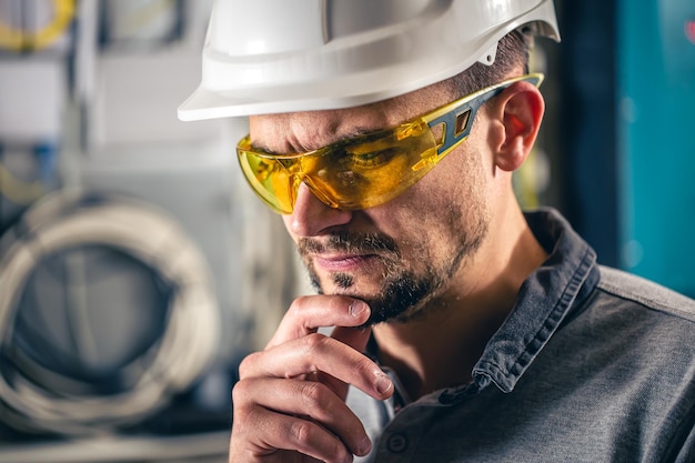 Man een elektrische technicus die werkt in een schakelbord met zekeringen