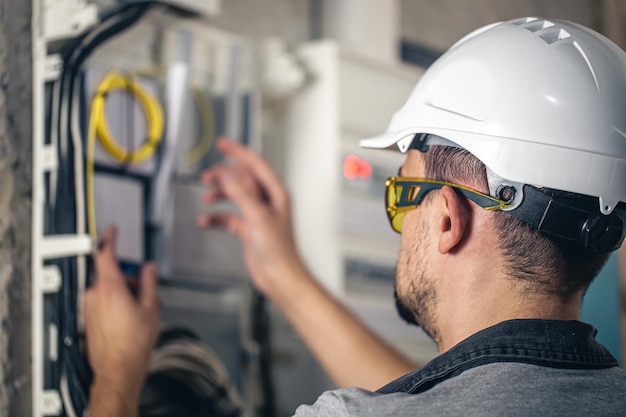 Gratis foto man een elektrische technicus die werkt in een schakelbord met zekeringen