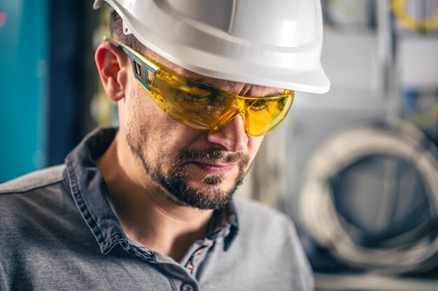 Man een elektrische technicus die werkt in een schakelbord met zekeringen