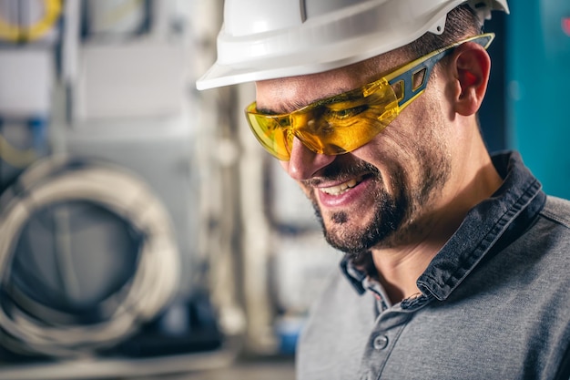 Man een elektrische technicus die werkt in een schakelbord met zekeringen