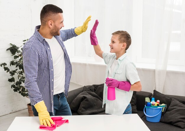 Man en jongen high-five elkaar voor het schoonmaken