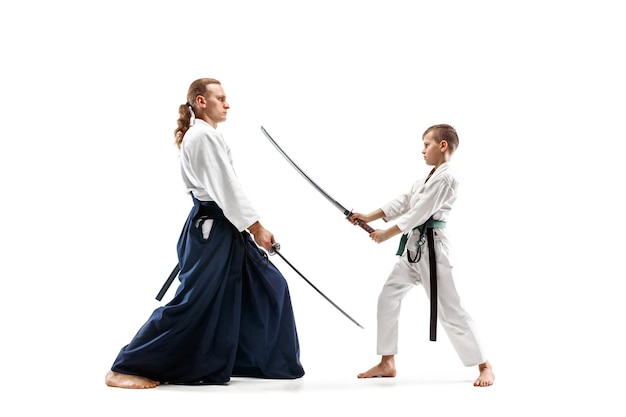 Man en tienerjongen die vechten bij Aikido-opleiding in vechtsportschool. Gezonde levensstijl en sportconcept.