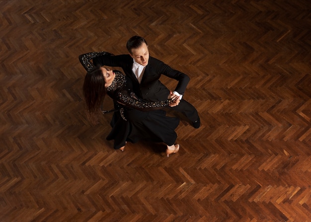 Gratis foto man en vrouw dansen samen in een balzaalscène