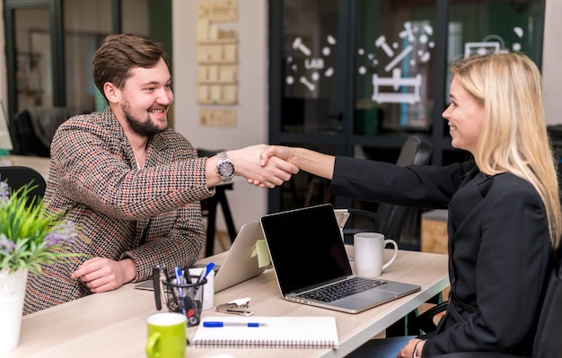 Man en vrouw die op het werk een deal sluiten