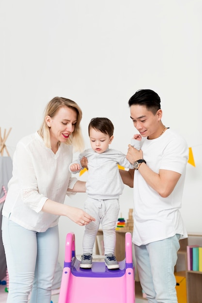 Man en vrouw die peuter helpen de dia gebruiken