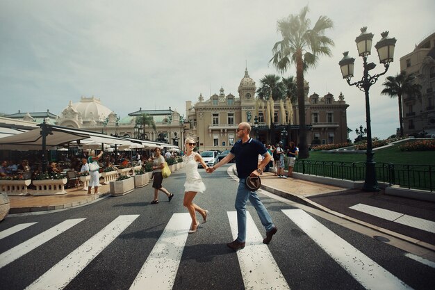 Man en vrouw houden elkaar hand over straat in Monte Carlo