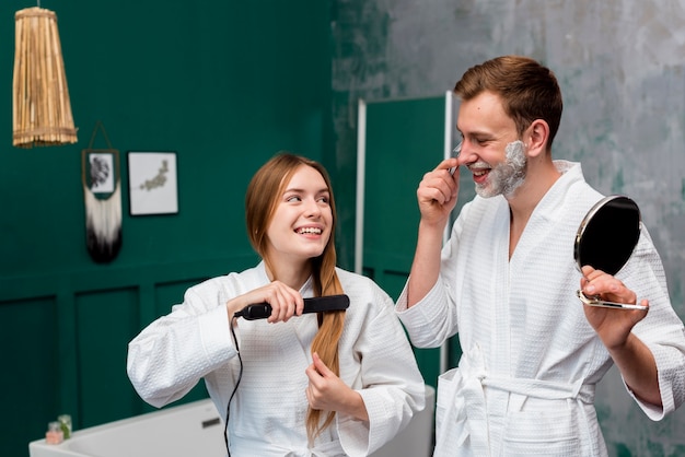 Man en vrouw in badjas doen hun ochtendroutine