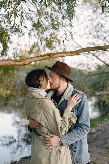 Man en vrouw in modekleren die samen op de natuur bij het meer rusten