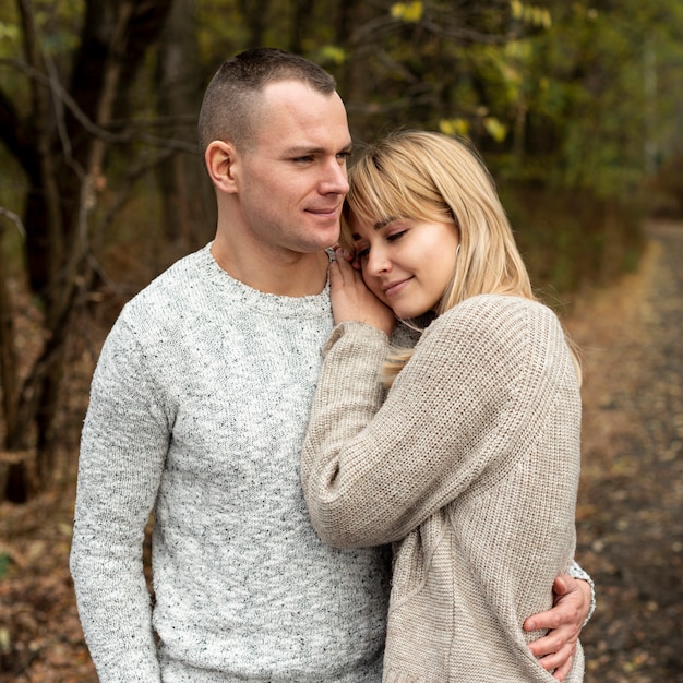 Man en vrouw knuffelen in de natuur