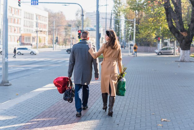 Man en vrouw met tassen gaan op straat