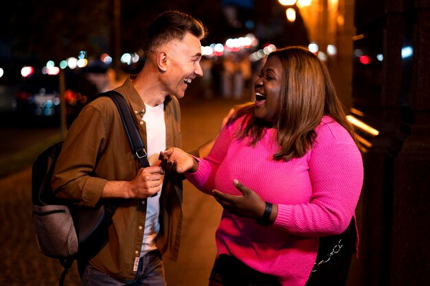 Man en vrouw praten 's nachts in de stadslichten