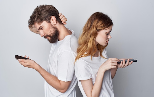 Man en vrouw ruzie jaloezie telefoons communicatie geïsoleerde achtergrond