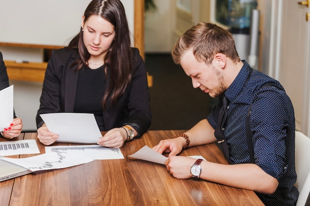 Man en vrouw zitten bij het lezen van een bureau