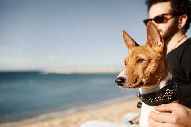 Man en zijn hond op het strand die de zee bewonderen