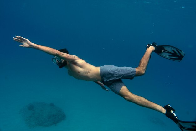 Man freediving met zwemvliezen onder water