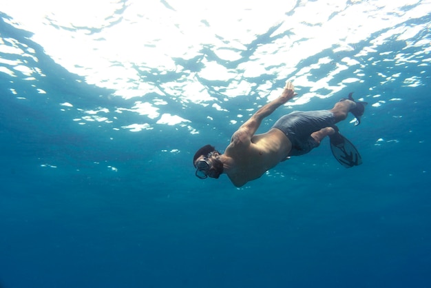 Man freediving met zwemvliezen onder water