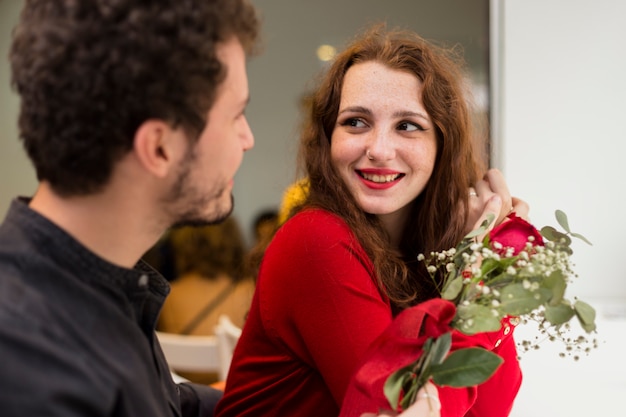 Gratis foto man gaf rode roos aan mooie vrouw