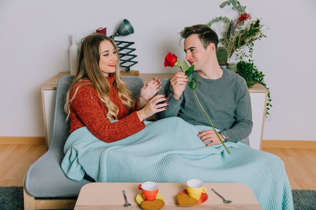 Man geeft roos aan vrouw