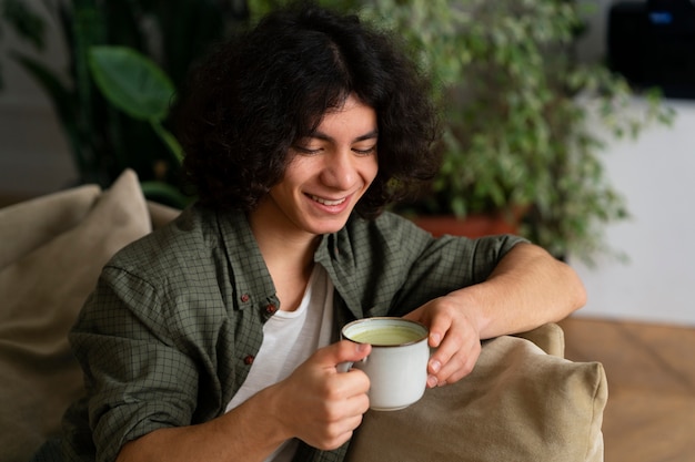 Gratis foto man geniet van een kopje matcha-thee