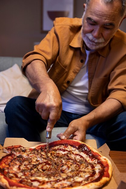 Man geniet van een pizza terwijl hij alleen thuis is