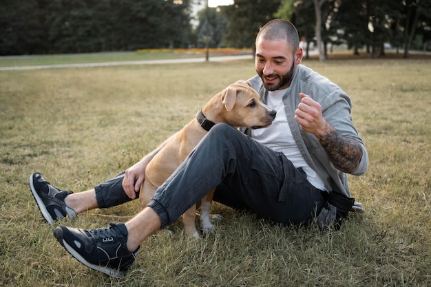 Gratis foto man geniet van wat quality time met zijn hond