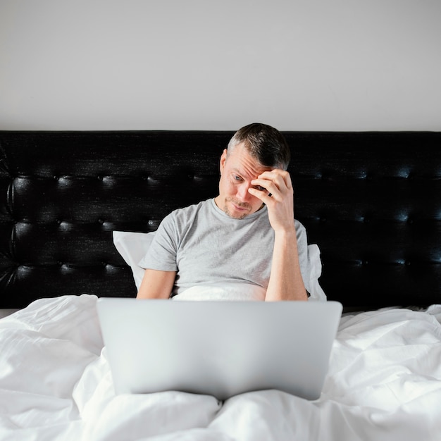 Man in bed met laptop