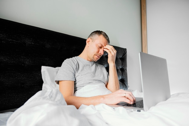 Man in bed met laptop