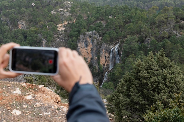 Gratis foto man in de natuur fotograferen met mobiel