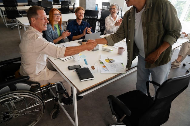 Man in een rolstoel met een inclusieve kantoorbaan