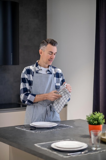 Man in een schort die glas afveegt met servet